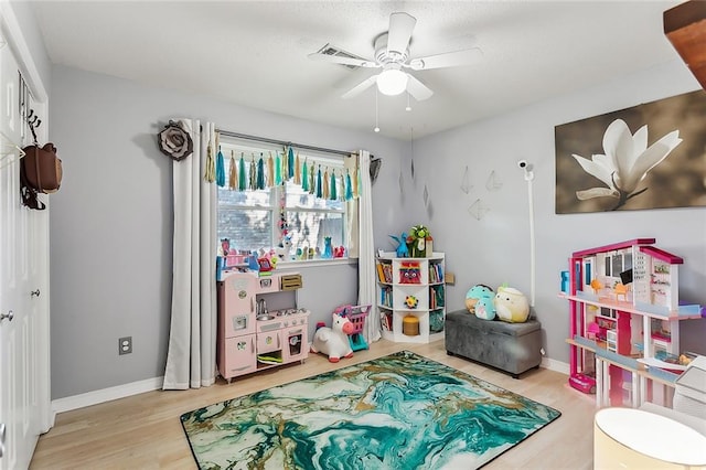 recreation room with light wood-type flooring and ceiling fan