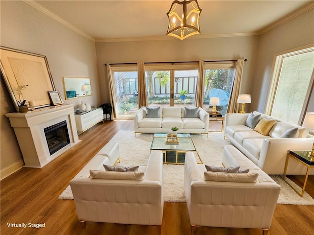 living area with a wealth of natural light, a glass covered fireplace, light wood-style flooring, and baseboards