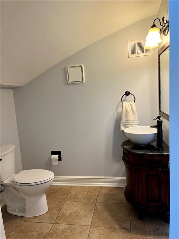 bathroom with visible vents, vaulted ceiling, vanity, and baseboards