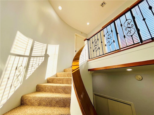 stairs with a high ceiling, visible vents, and recessed lighting