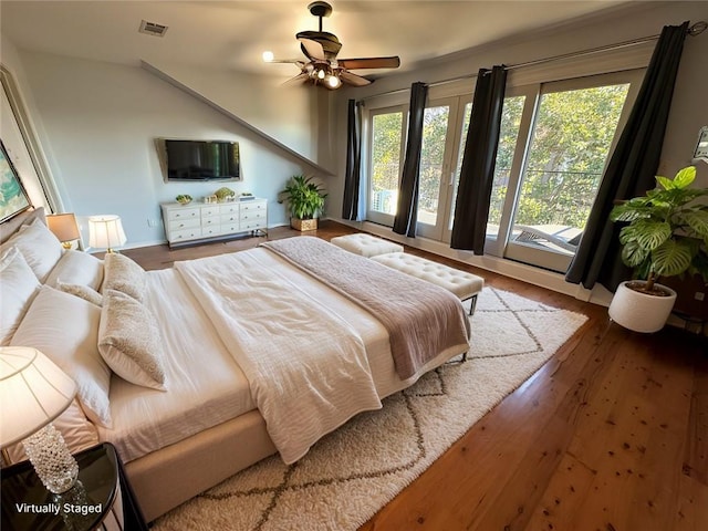 bedroom featuring wood finished floors, visible vents, and a ceiling fan