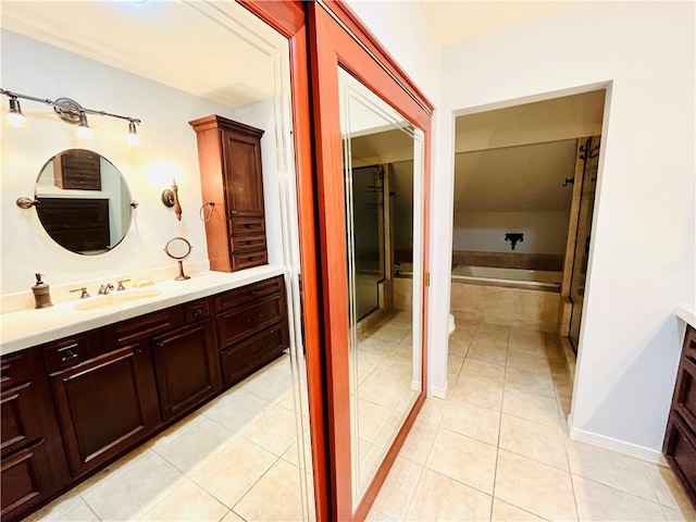 bathroom with a garden tub, vanity, and tile patterned floors