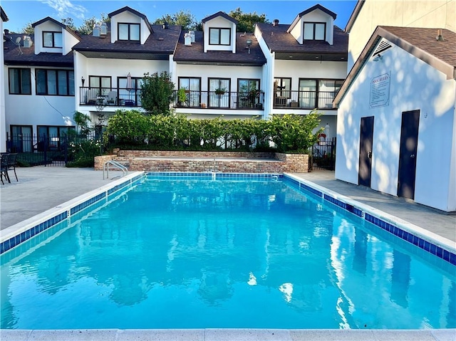 back of house with fence, a community pool, and stucco siding