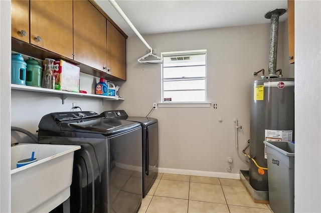 washroom featuring cabinets, light tile patterned floors, gas water heater, independent washer and dryer, and sink