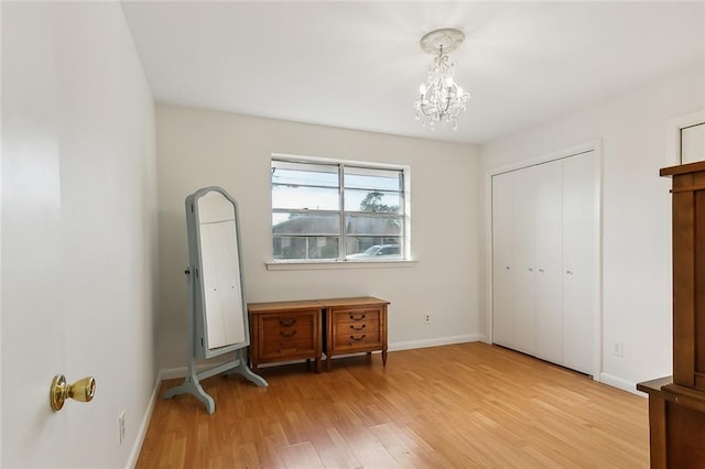 bedroom featuring a chandelier and light wood-type flooring