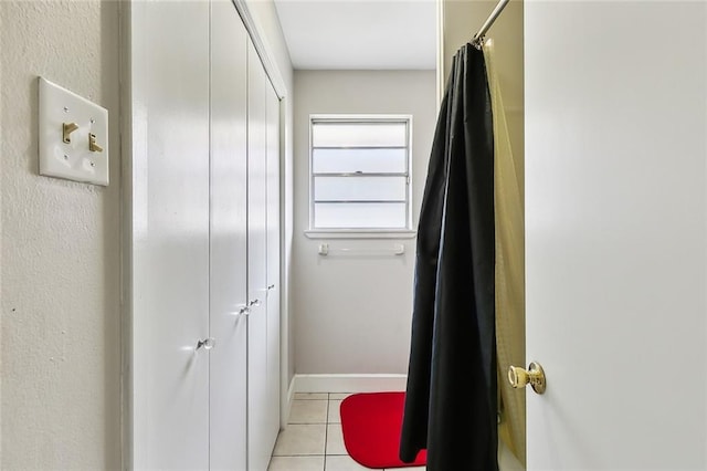 bathroom with a shower with curtain and tile patterned flooring