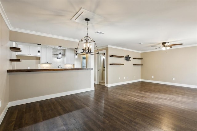 interior space with ceiling fan with notable chandelier, dark hardwood / wood-style floors, and ornamental molding