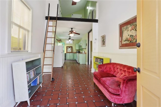 living area with dark tile patterned floors and high vaulted ceiling