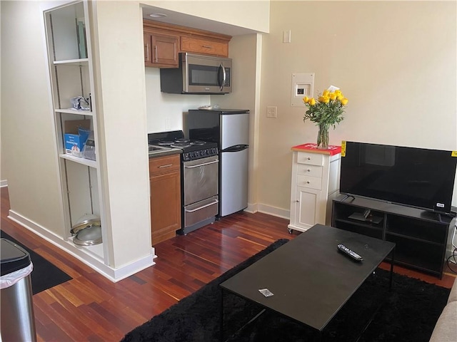 kitchen with appliances with stainless steel finishes and dark hardwood / wood-style flooring