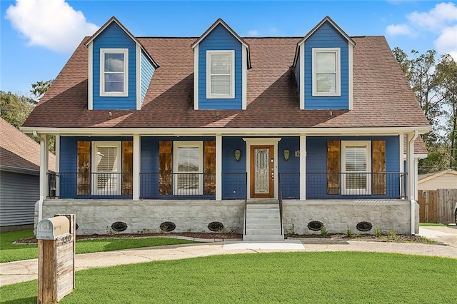 cape cod house featuring a front yard and covered porch