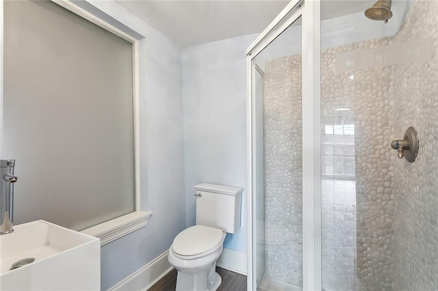 bathroom featuring a shower with door, toilet, sink, and hardwood / wood-style floors