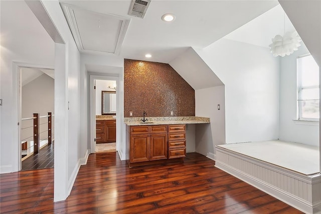 bar with tasteful backsplash, sink, and dark wood-type flooring