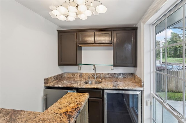 bar with wine cooler, sink, and dark brown cabinets