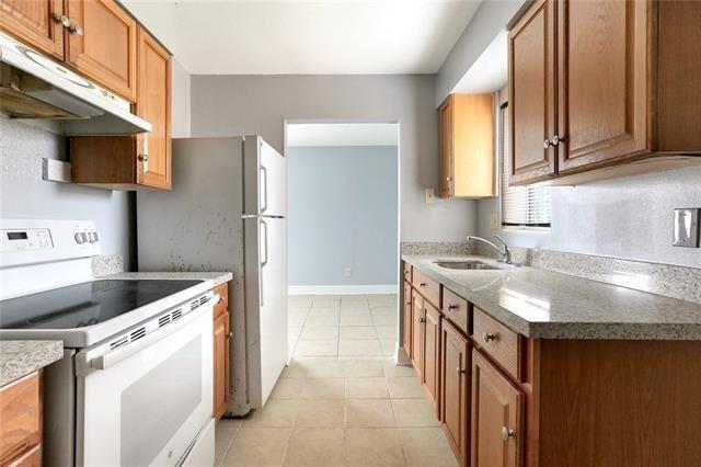 kitchen with sink, light tile patterned floors, and white electric stove