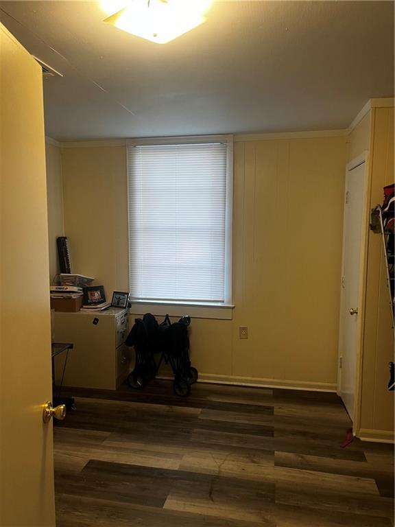 interior space with ornamental molding and dark wood-type flooring