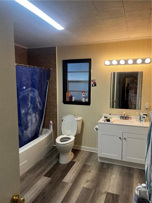 full bathroom featuring shower / tub combo with curtain, vanity, toilet, and hardwood / wood-style floors