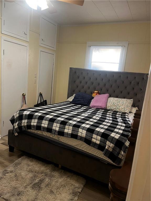 bedroom with hardwood / wood-style flooring, crown molding, and ceiling fan