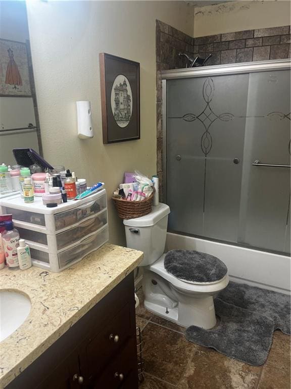 full bathroom with vanity, toilet, and bath / shower combo with glass door