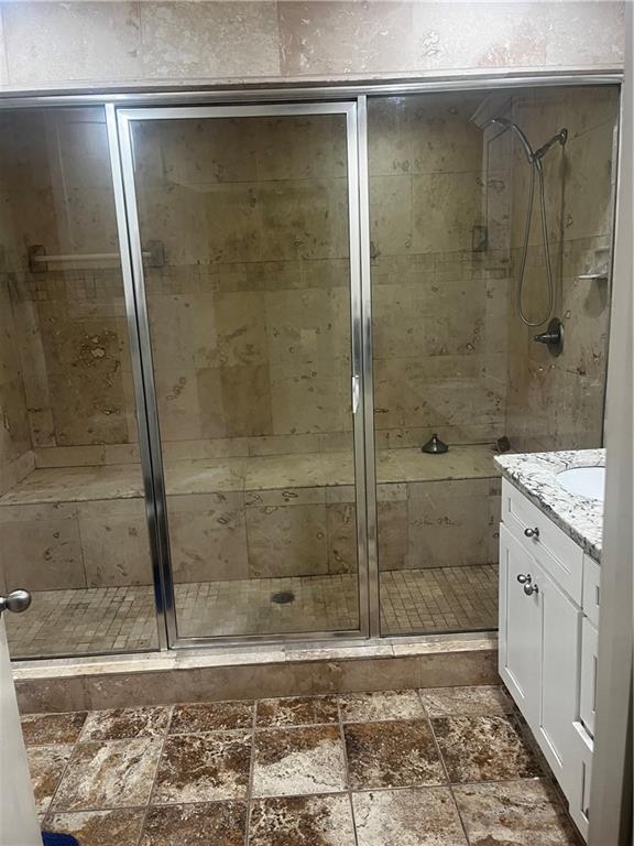 bathroom featuring vanity and a shower with door