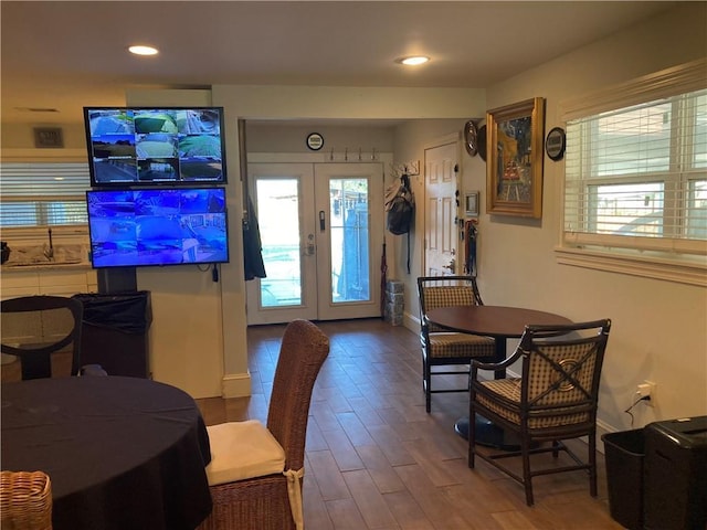 dining space with wood-type flooring and french doors