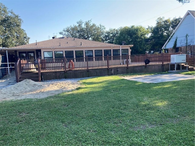 rear view of property featuring a yard, a patio area, and a wooden deck