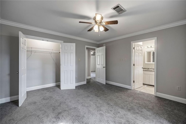 unfurnished bedroom featuring light colored carpet, ceiling fan, crown molding, connected bathroom, and a closet