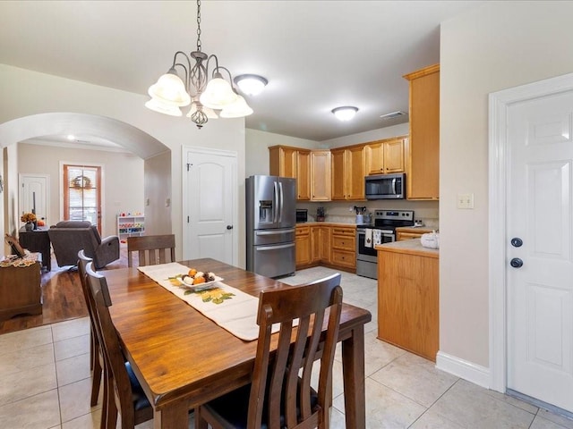 dining space with light tile patterned flooring and an inviting chandelier