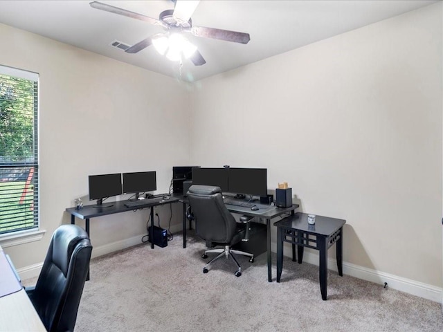 carpeted office space featuring ceiling fan