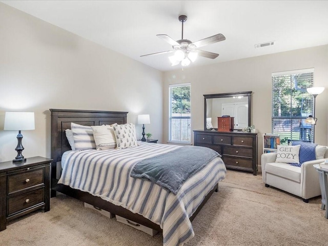 carpeted bedroom featuring multiple windows and ceiling fan