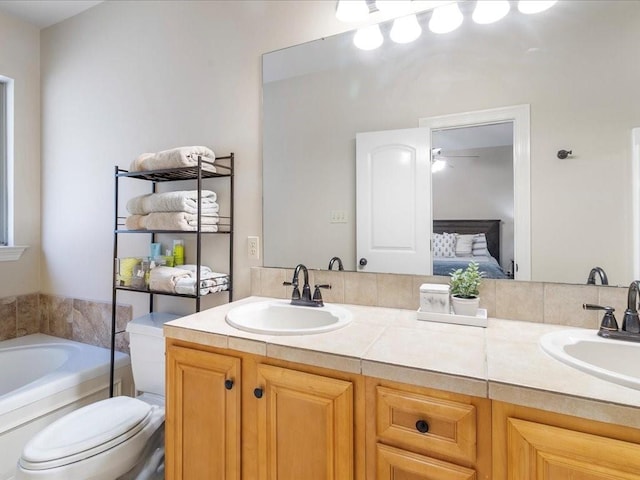 bathroom with vanity, toilet, and a bathing tub