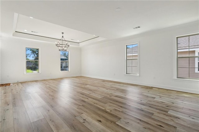 empty room with a wealth of natural light and light hardwood / wood-style floors