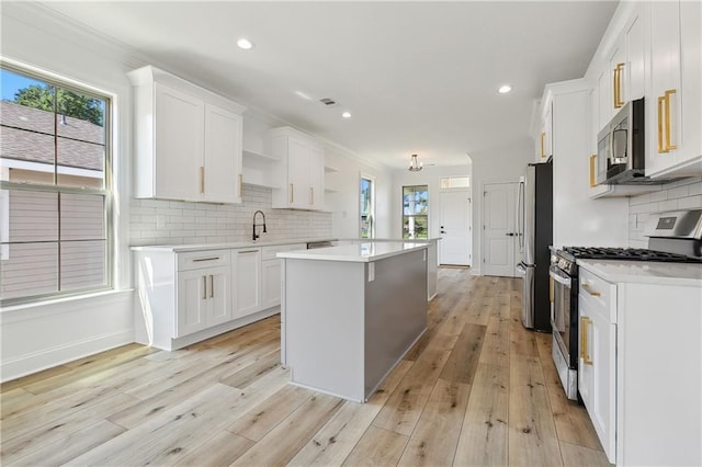 kitchen with white cabinets, a healthy amount of sunlight, and appliances with stainless steel finishes