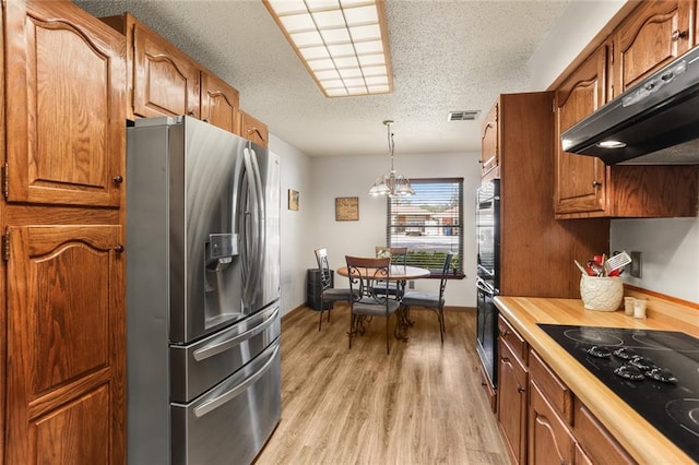 kitchen with stainless steel fridge with ice dispenser, light hardwood / wood-style flooring, a notable chandelier, decorative light fixtures, and black cooktop