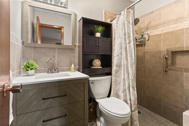 bathroom with backsplash, vanity, curtained shower, and toilet