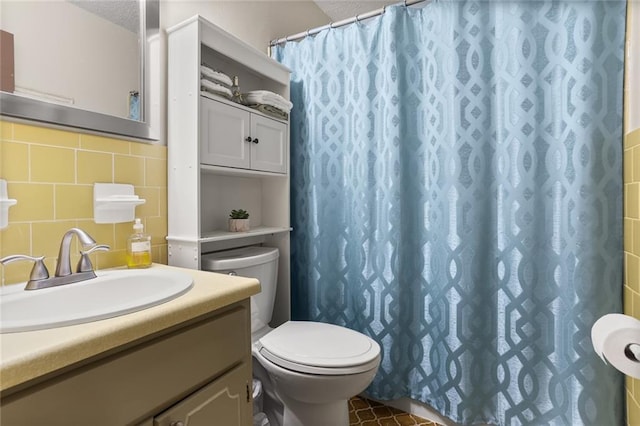 bathroom with a textured ceiling, tile walls, toilet, vanity, and a shower with shower curtain