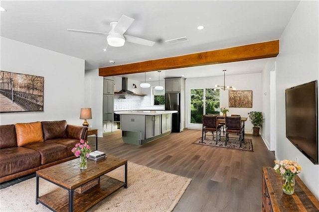 living room with beamed ceiling, ceiling fan with notable chandelier, and dark hardwood / wood-style flooring