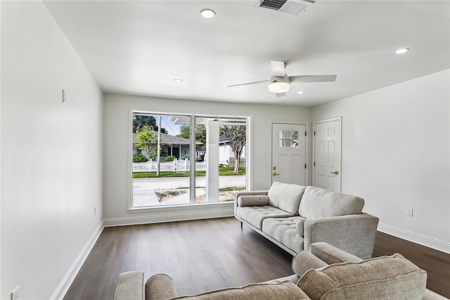 living room with ceiling fan and dark wood-type flooring