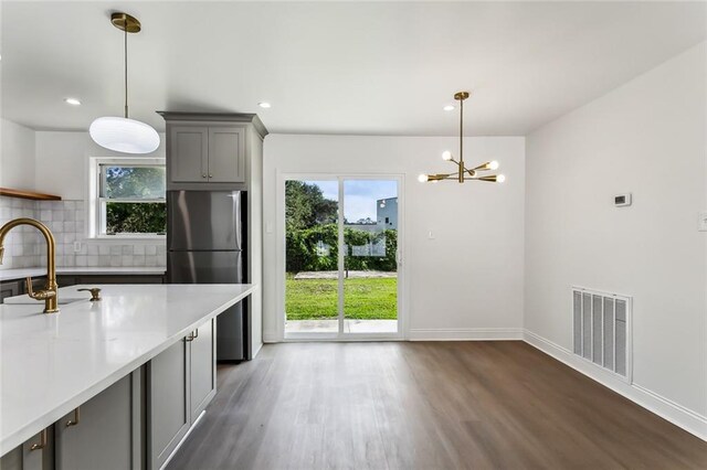 kitchen with decorative backsplash, decorative light fixtures, dark hardwood / wood-style flooring, and gray cabinets