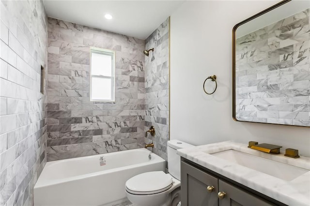 full bathroom with toilet, vanity, and tiled shower / bath