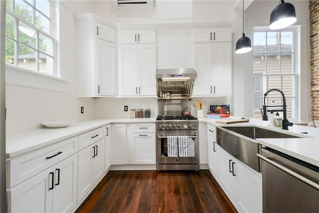 kitchen featuring appliances with stainless steel finishes, dark wood-type flooring, hanging light fixtures, and brick wall