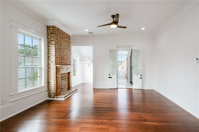 unfurnished living room featuring a brick fireplace, ceiling fan, crown molding, and dark hardwood / wood-style flooring