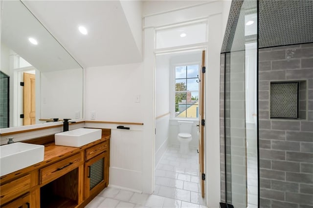 bathroom with toilet, a shower with shower door, vanity, and tile patterned flooring