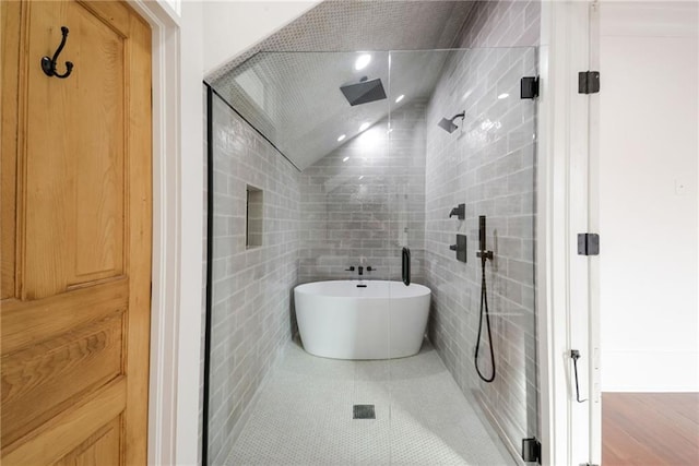 bathroom with tile patterned floors, tile walls, and separate shower and tub