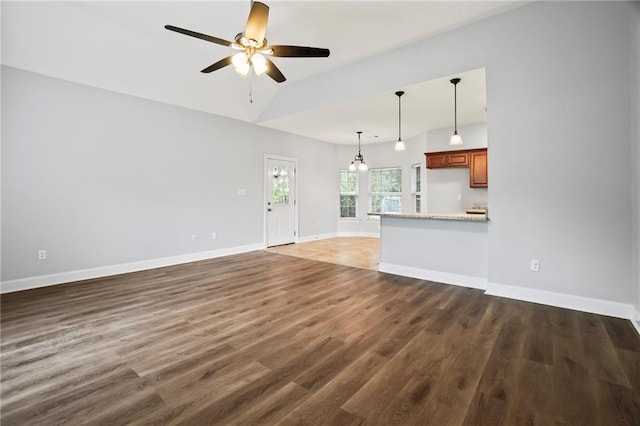 unfurnished living room featuring baseboards, ceiling fan, dark wood-style flooring, and lofted ceiling