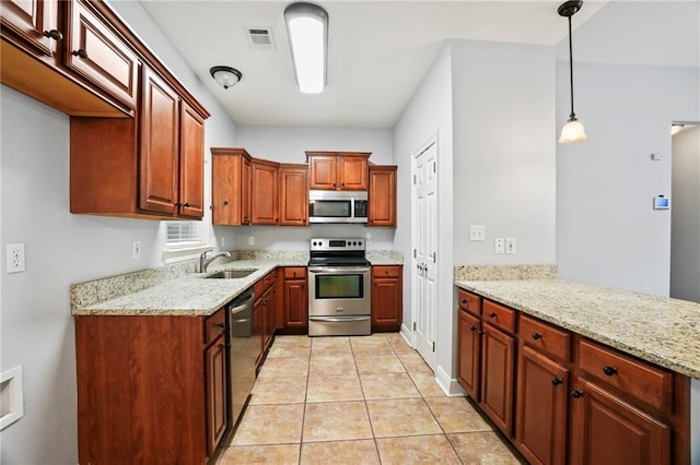 kitchen with light stone counters, a sink, appliances with stainless steel finishes, and light tile patterned floors