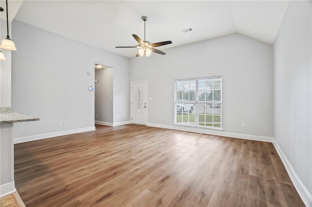 unfurnished living room featuring ceiling fan, baseboards, wood finished floors, vaulted ceiling, and visible vents