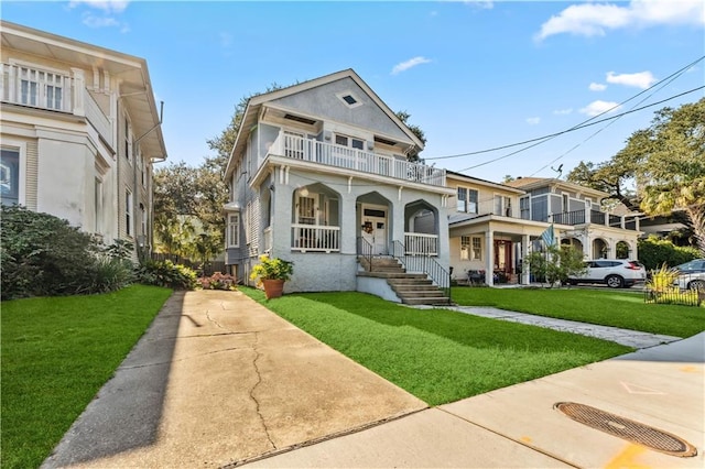 view of front of house featuring covered porch, a balcony, and a front lawn