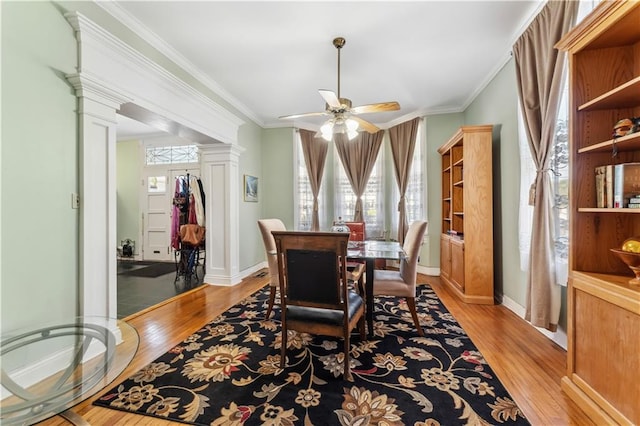 dining area with decorative columns, light hardwood / wood-style flooring, plenty of natural light, and ceiling fan