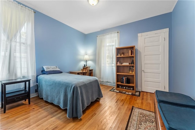 bedroom featuring multiple windows and light wood-type flooring