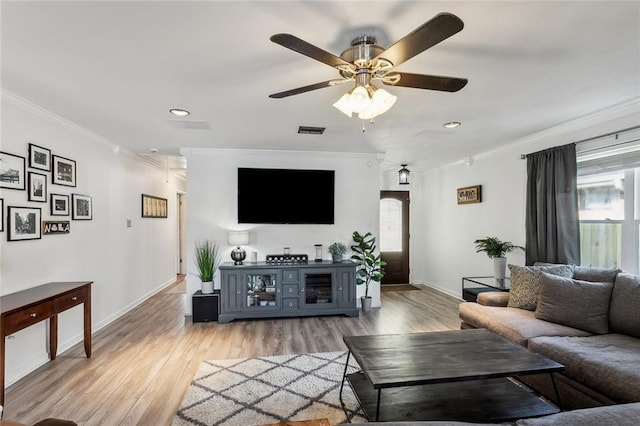 living area with baseboards, ornamental molding, a healthy amount of sunlight, and visible vents